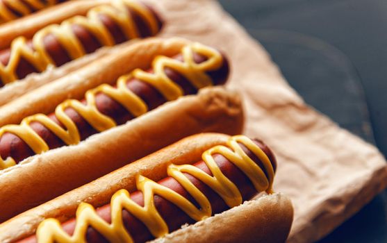 Barbecue Grilled Hot Dogs with  yellow American mustard, On a dark wooden background