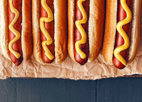 Barbecue Grilled Hot Dogs with  yellow American mustard, On a dark wooden background