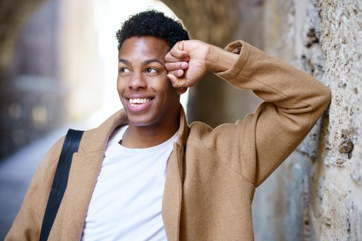 Happy black man smiling outdoors. Cuban student in urban background.