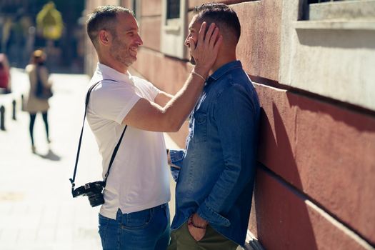 Gay couple tourists in a romantic moment on the street. Homosexual relationship concept.