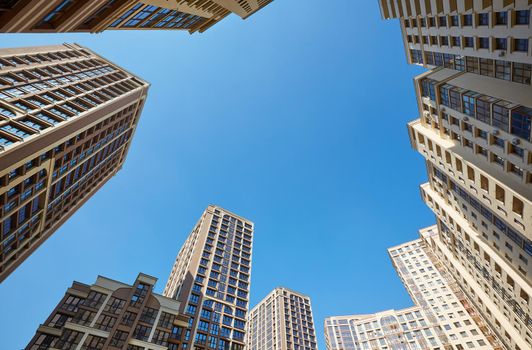 modern block of flats. Bottom view of residential house courtyad on blue sky. residential apartment with flat buildings exterior. luxury house complex. condo architecture. apartment insurance concept