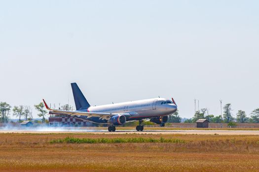 Passenger plane taking off from runway at airport on sunny day photo