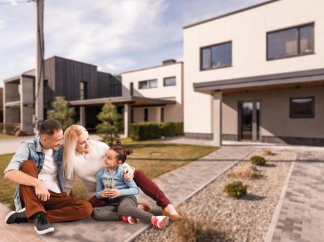Happy family. family on the background of a new house. Modern new house is on the background