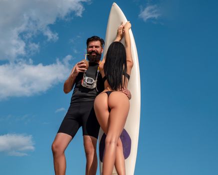 Sexy summer couples. Happy couple with Surfboard on the beach