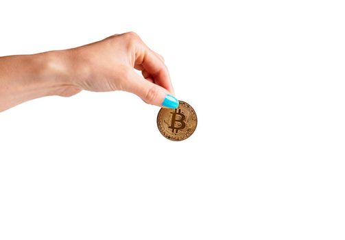Woman’s hand holding gold coin bitcoin on a white background, symbol of crypto currency.