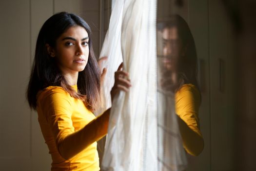 Persian woman at home while looking through the window