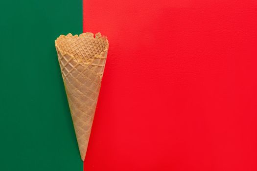 Top view at the empty waffle cone on red and green background, special concept, enough place for text, diagonal position