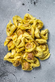 Uncooked raw ravioli with Mozzarella and Tomato. Gray background. Top view.