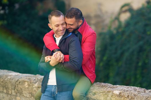 Gay couple in a romantic moment in a beautiful place near the river. Homosexual relationship concept.