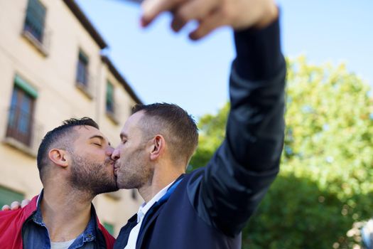 Gay couple making a selfie with their smartphone. LGTB relationship concept.
