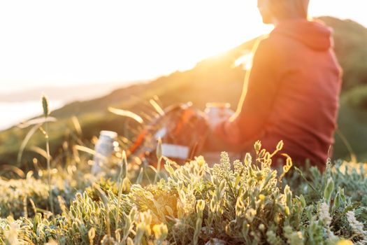 Traveler young woman resting in mountains in spring. Focus on foreground.