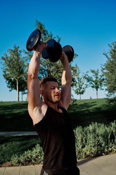 sporty man exercise fitness workout outdoors with dumbbells. High quality photo