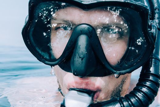 Close-up portrait of young man in mask with snorkel outdoor.