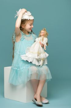 Adorable little girl playing with a doll. Concept of children's games, happy family.