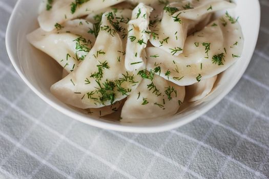 Dumplings, filled with potatoes and served with butter and fennel. Varenyky, vareniki, pierogi, pyrohy. Dumplings with filling