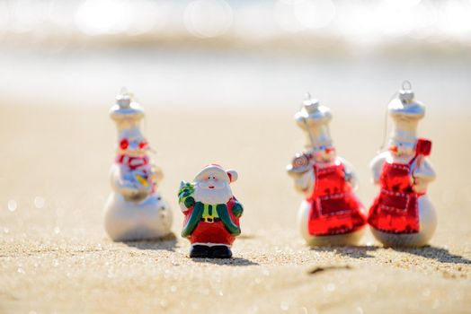 New Year and Summer travel. Snow man and Santa on sea beach. Christmas and vacation
