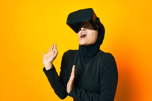 cheerful woman in black hijab VR glasses emotions studio lifestyle. High quality photo