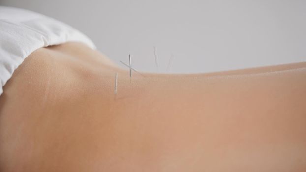 Young female relaxing in spa salon before oil sesame massage, close up