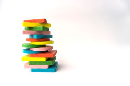 Toy colourful bricks lay one at each other on white background, isolated, copy space.