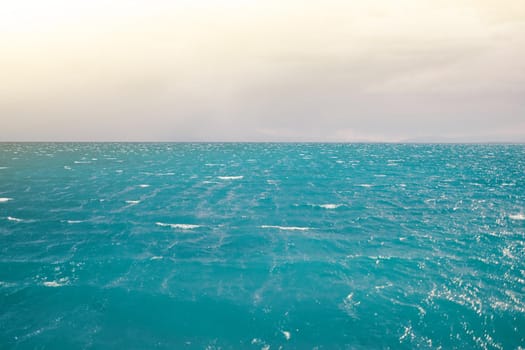 Seascape with clear horizon line and cloudy sky. Travel background. Ripple wave and calm ocean.