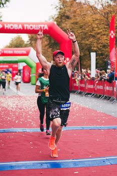 POLTAVA, UKRAINE - 1 SEPTEMBER 2019: A stylish man reaches finish line during Nova Poshta Poltava Half Marathon.