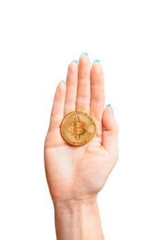 One gold bitcoin on female palm hand on a white background, symbol of crypto currency and virtual money.