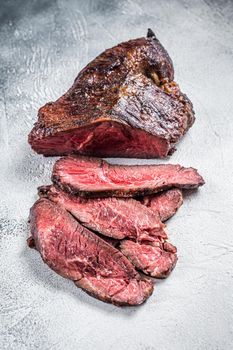 Roasted hanger or Onglet sliced beef meat steak on a table. White background. Top View.