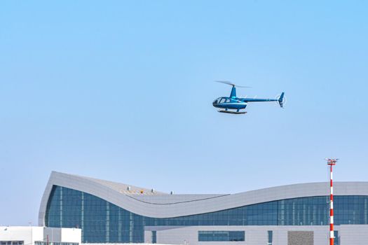 Helicopter flying in the blue sky during a sunny day