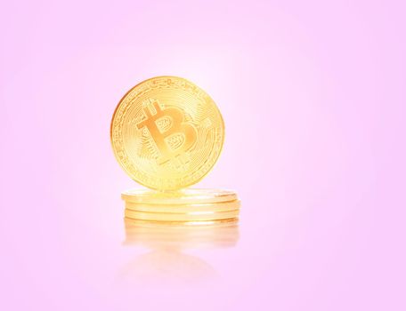 Stack of glowing gold coins bitcoins on a pink background.