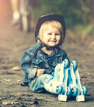 cute little girl on roller skates with helmet in the park