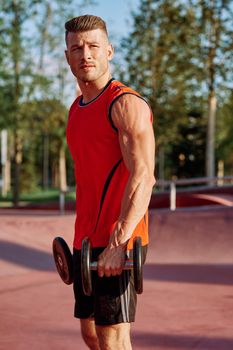 Muscled Man With Dumbbells Outdoor Workout. High quality photo