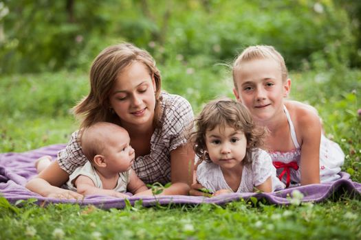 Happy family on green grass in the garden