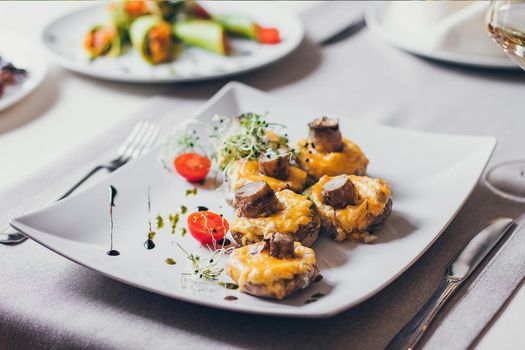 Stuffed mushrooms filled with cheese, mushroom stems, fresh cherry tomatoes and microgreen.