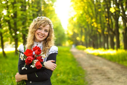 Girl is walking in the park. Cute woman with flowers