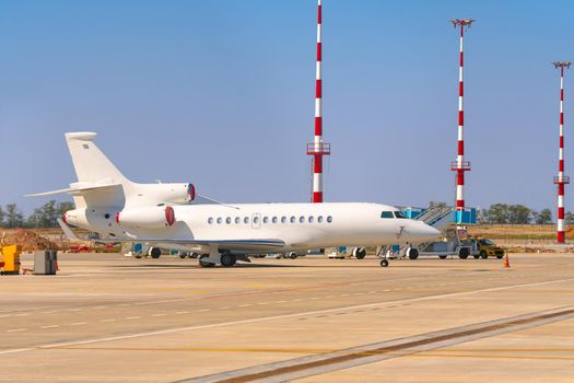 Airplane is parked near gate of airport terminal on sunny day