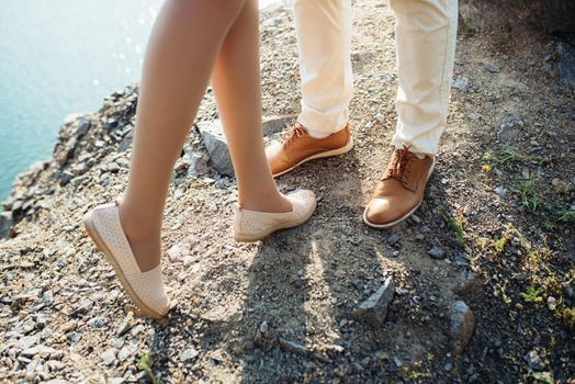 a young couple a guy and a girl are walking near a mountain lake surrounded by granite rocks