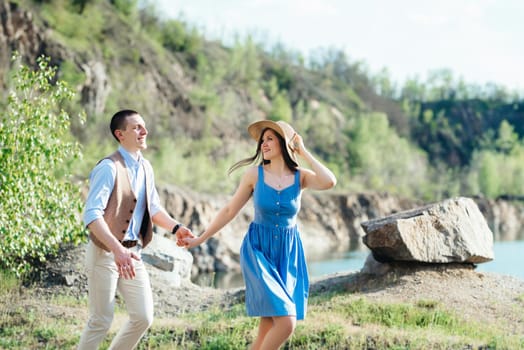 a young couple a guy and a girl are walking near a mountain lake surrounded by granite rocks
