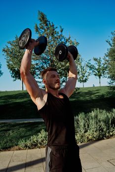 sporty man exercise fitness workout outdoors with dumbbells. High quality photo