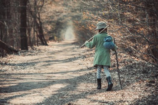 little girl goes on a footpath in the forest photo in retro style