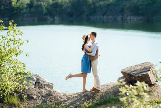 a young couple a guy and a girl are walking near a mountain lake surrounded by granite rocks