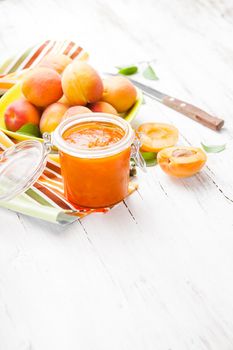 Fleshy apricots in the bowl and fresh jam in a jar