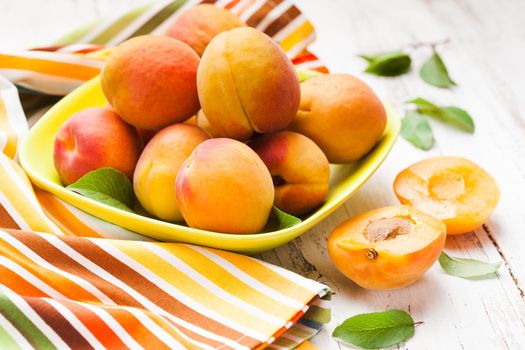 Fleshy apricots in the bowl on the table