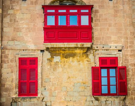 traditional red balcony and windows with shutter in Vattella street in Malta