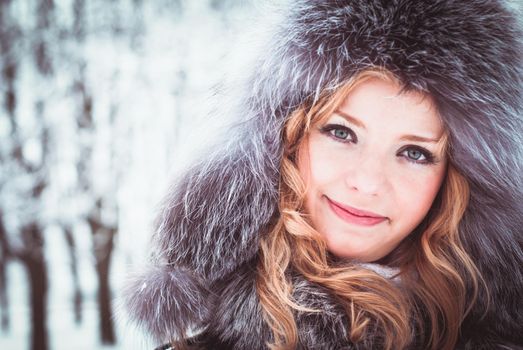 Woman is walking in park alley in winter