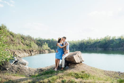 a young couple a guy and a girl are walking near a mountain lake surrounded by granite rocks