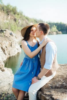 a young couple a guy and a girl are walking near a mountain lake surrounded by granite rocks