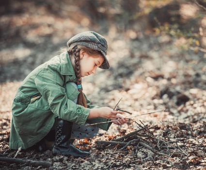 little girl making a bonfire, photo in vintage style