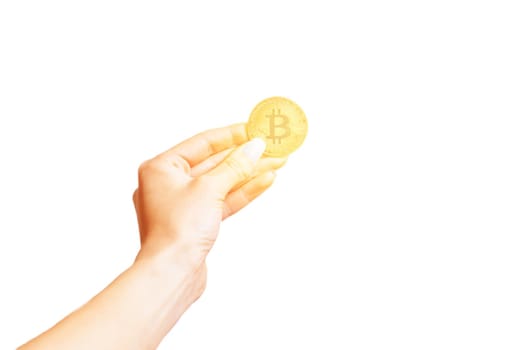 Female hand holding glowing gold bitcoin isolated on a white background.