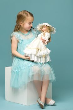 Adorable little girl playing with a doll. Concept of children's games, happy family.