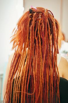 View from back of girl with colorful dreadlocks from kanekalon. Fashion beauty and stylish hair.